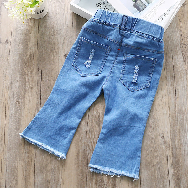 Blugi moderni pentru copii pentru o fată cu motive rupte și plasă