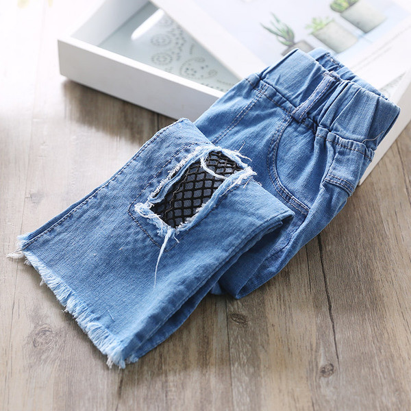 Blugi moderni pentru copii pentru o fată cu motive rupte și plasă