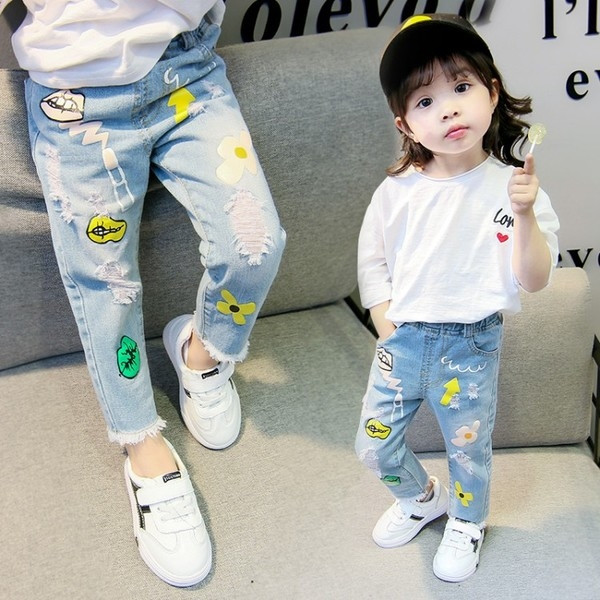 Blugi de copii pentru o fată cu aplicații și motive rupte