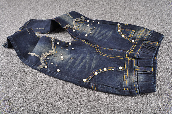 Blugi moderni pentru copii pentru o fată cu perle decorative într-o culoare închisă