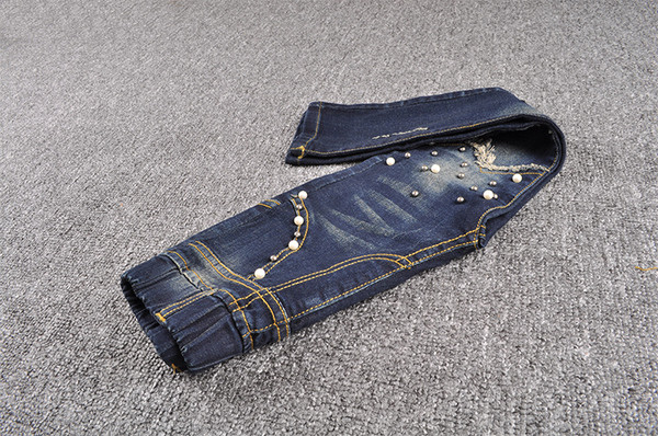 Blugi moderni pentru copii pentru o fată cu perle decorative într-o culoare închisă