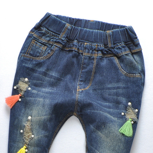 Blugi de copii pentru o fata cu ciucuri colorati si motive rupte