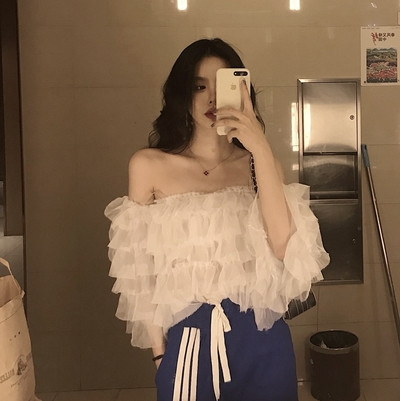 Σύντομο γυναικείο μπλουζάκι  με ανοιχτούς ώμους και ανοιχτού χρώματος βολάν