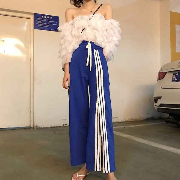 Σύντομο γυναικείο μπλουζάκι  με ανοιχτούς ώμους και ανοιχτού χρώματος βολάν