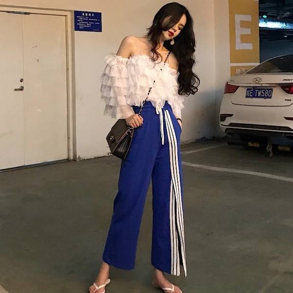 Σύντομο γυναικείο μπλουζάκι  με ανοιχτούς ώμους και ανοιχτού χρώματος βολάν