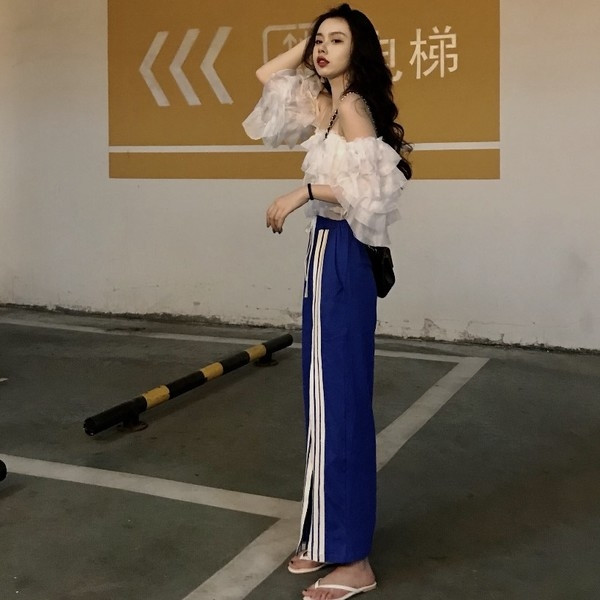 Σύντομο γυναικείο μπλουζάκι  με ανοιχτούς ώμους και ανοιχτού χρώματος βολάν