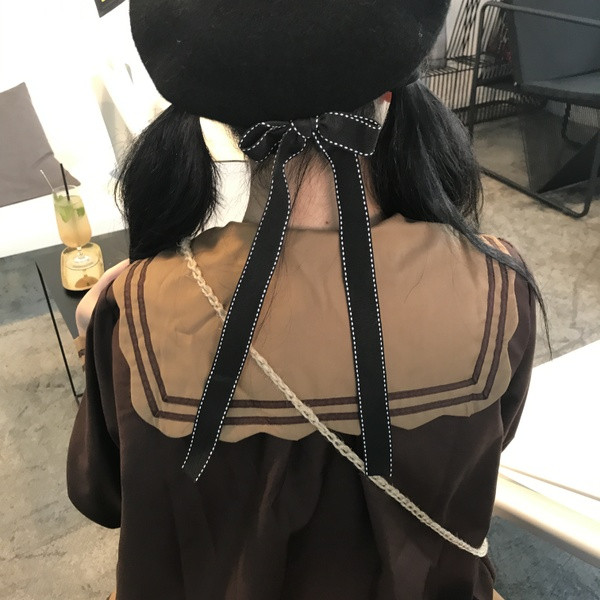 Pălărie modernă de iarnă pentru femei cu o panglică în negru