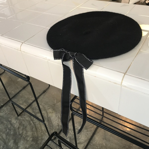 Pălărie modernă de iarnă pentru femei cu o panglică în negru