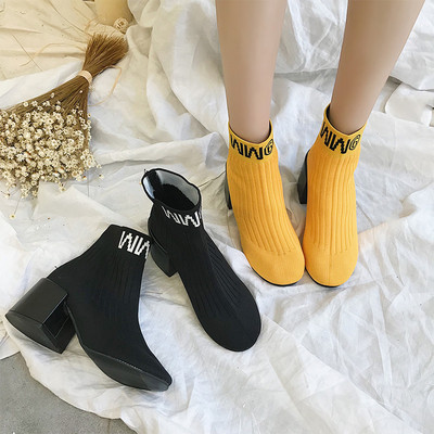 Σύγχρονες μπότες κυρίες με παχύ ρεύμα και επιγραφή σε μαύρο και κίτρινο χρώμα