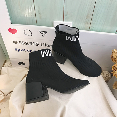 Σύγχρονες μπότες κυρίες με παχύ ρεύμα και επιγραφή σε μαύρο και κίτρινο χρώμα