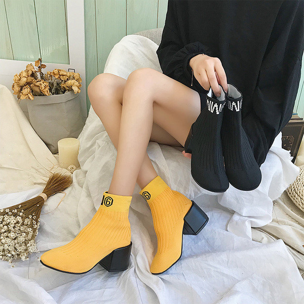 Σύγχρονες μπότες κυρίες με παχύ ρεύμα και επιγραφή σε μαύρο και κίτρινο χρώμα