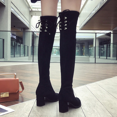 Μοντέρνες γυναικείες  μπότες  με  χοντρό τακούνι  και σταυρωτές συνδέσεις σε μαύρο χρώμα