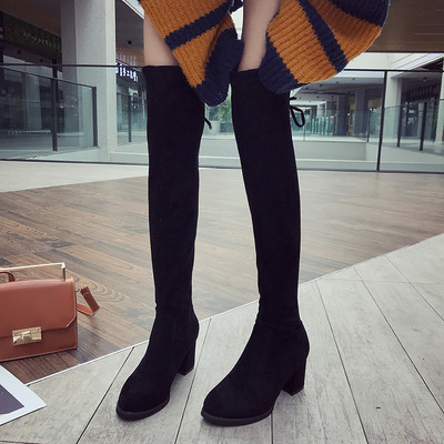 Μοντέρνες γυναικείες  μπότες  με  χοντρό τακούνι  και σταυρωτές συνδέσεις σε μαύρο χρώμα