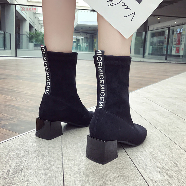 Stílusos női csizma vastag sarokkal és fekete feliratokkal