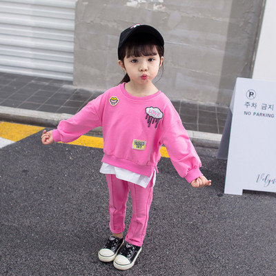 Gyerekkészlet lányoknak rózsaszínben két részből áll - emblémákkal ellátott blúz és nadrág