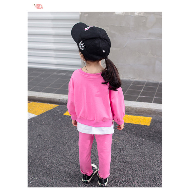 Gyerekkészlet lányoknak rózsaszínben két részből áll - emblémákkal ellátott blúz és nadrág