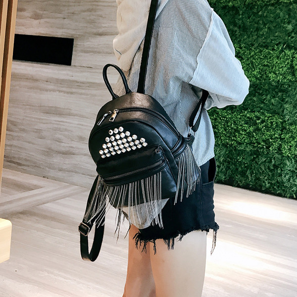 Női hátizsák rojtokkal és fém lyukakkal, fekete színben