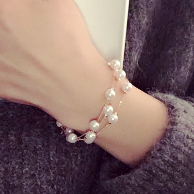 Modern női karkötő gyöngyökkel, arany színben