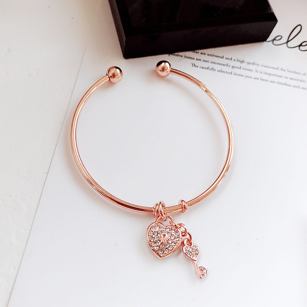 Μοντέρνο γυναικείο βραχιόλι σε χρυσό χρώμα με κρεμαστό κόσμημα