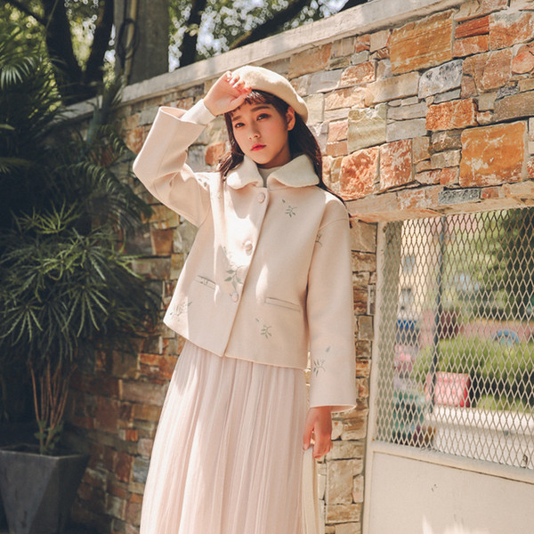 Rövid, világos színű női kabát puha gallérral és virágmotívumokkal