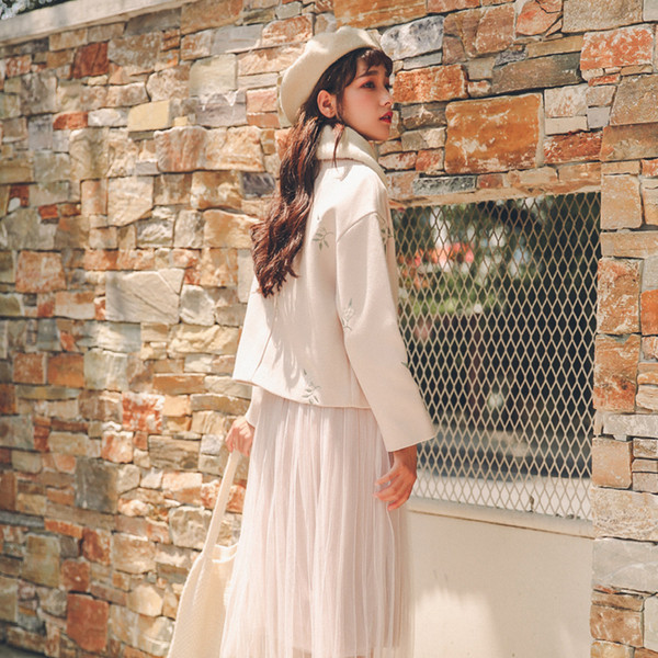 Rövid, világos színű női kabát puha gallérral és virágmotívumokkal