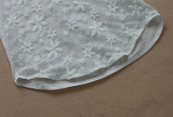 Stílusos női blúz V-nyakkal és virágmotívumokkal, fehér színben