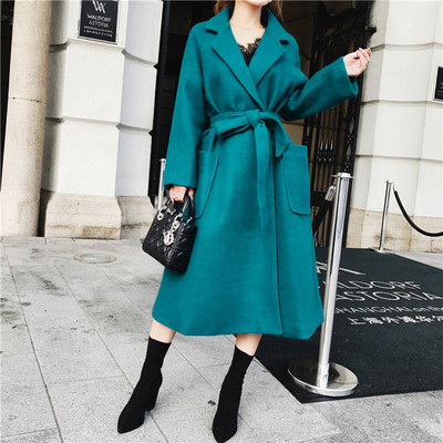 Modern női kabát zsebekkel és kék övvel