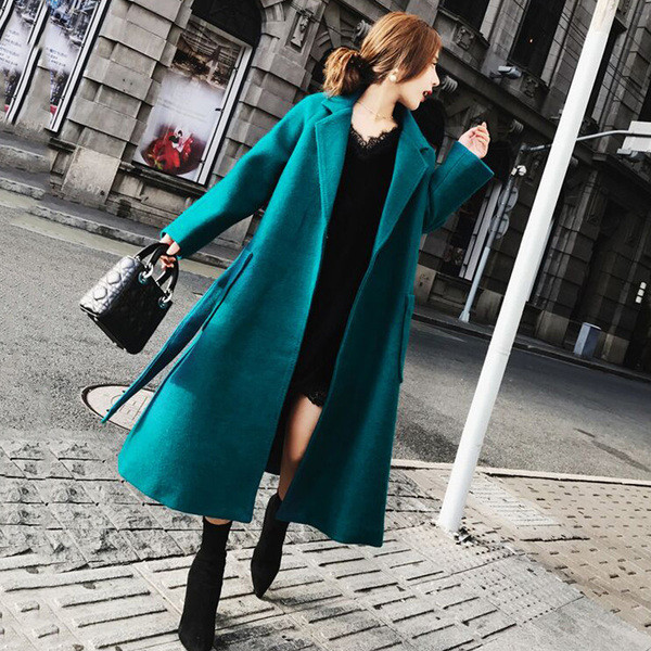 Modern női kabát zsebekkel és kék övvel