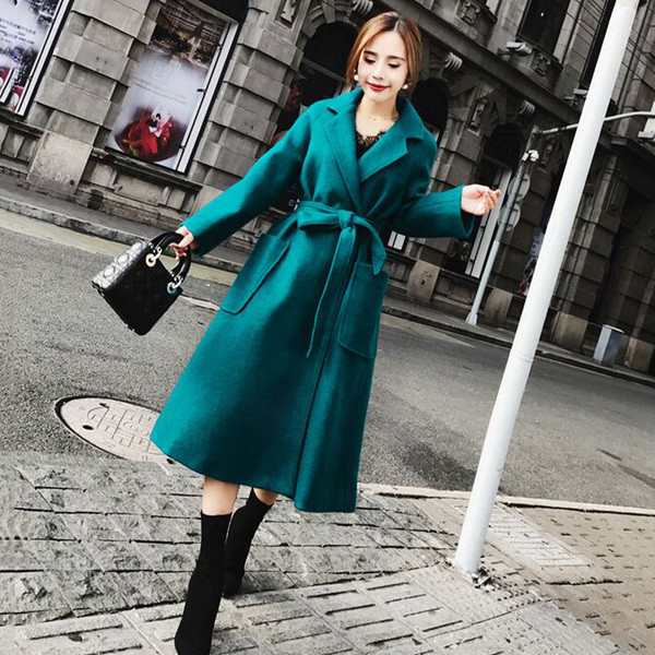 Modern női kabát zsebekkel és kék övvel