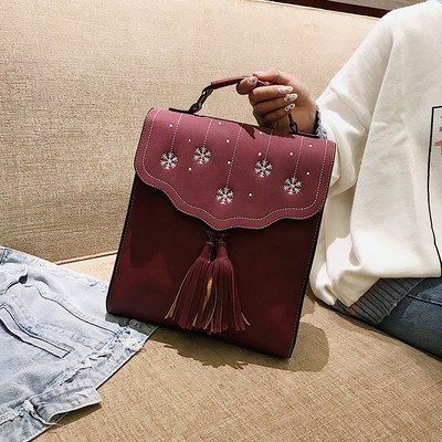 Több színben hímzéssel és bojttal ellátott női hátizsák