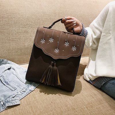 Több színben hímzéssel és bojttal ellátott női hátizsák