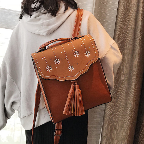 Több színben hímzéssel és bojttal ellátott női hátizsák