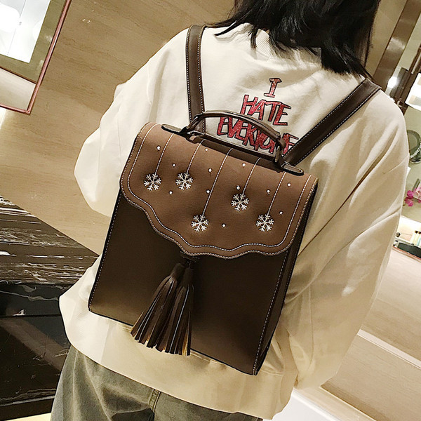 Több színben hímzéssel és bojttal ellátott női hátizsák