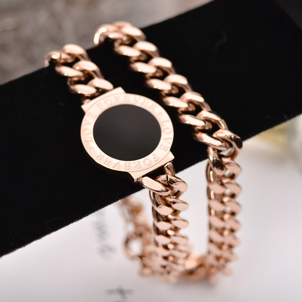 Elegáns női karkötő fekete kővel és arany színű feliratokkal