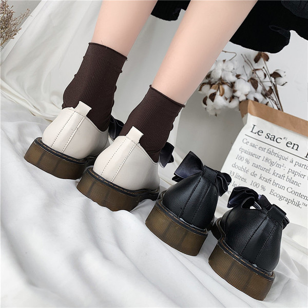 Modern női cipő fehér és fekete szalaggal