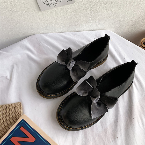 Modern női cipő fehér és fekete szalaggal