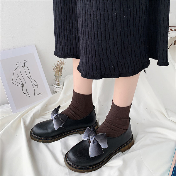 Modern női cipő fehér és fekete szalaggal