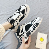 Modern férfi tornacipő magas talppal, fehér és fekete színben, feliratokkal