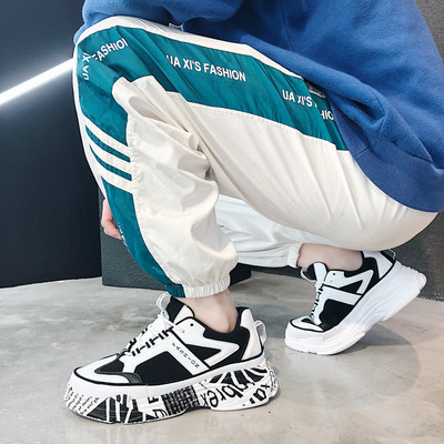 Modern férfi tornacipő magas talppal, fehér és fekete színben, feliratokkal