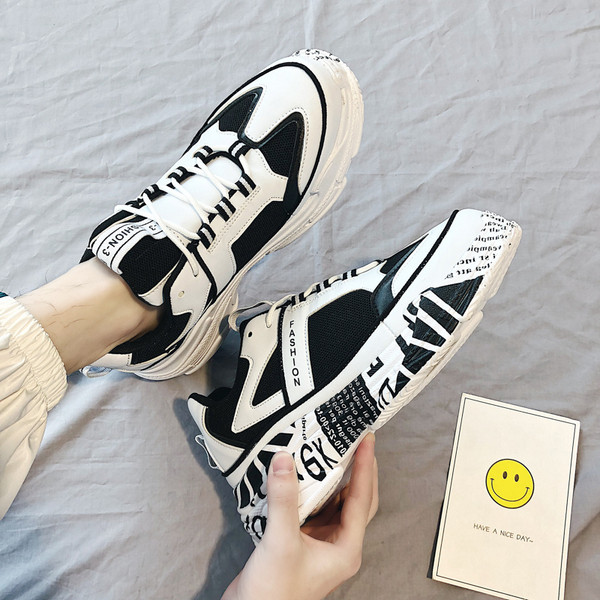 Modern férfi tornacipő magas talppal, fehér és fekete színben, feliratokkal