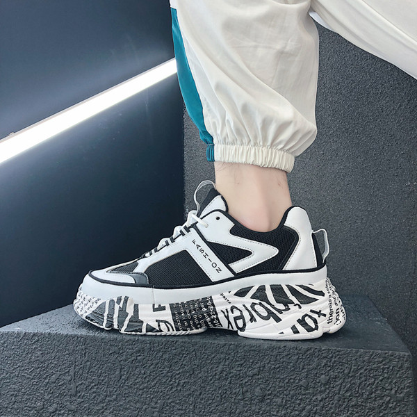 Modern férfi tornacipő magas talppal, fehér és fekete színben, feliratokkal