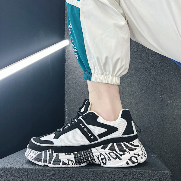 Modern férfi tornacipő magas talppal, fehér és fekete színben, feliratokkal