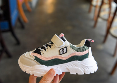 Gyerek hétköznapi tornacipő foltokkal és durva talppal