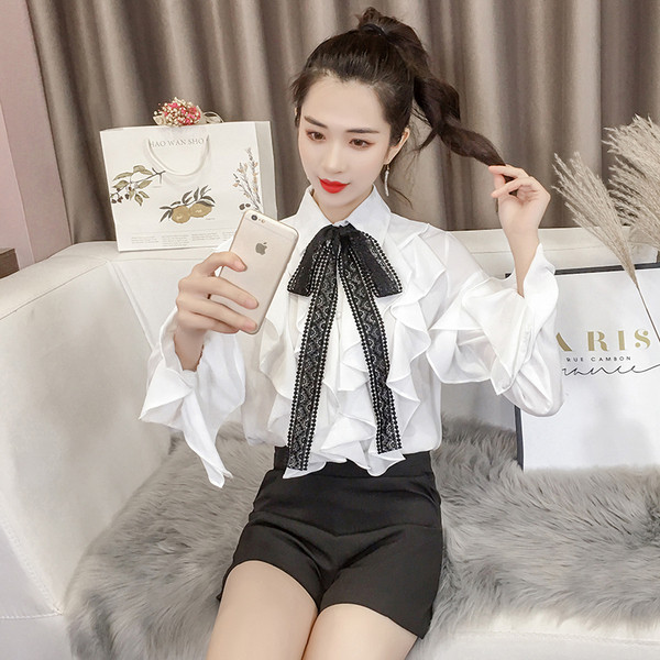 Modern női ing fehér színben, hosszú ujjal és szalaggal