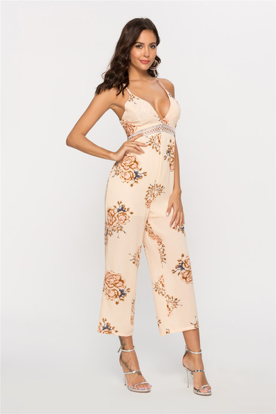 Stílusos női jumpsuit mély V-nyakkal és bézs színű virágmotívumokkal