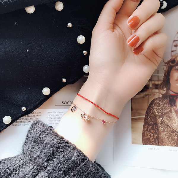 Piros és arany színű női karkötő függőkkel