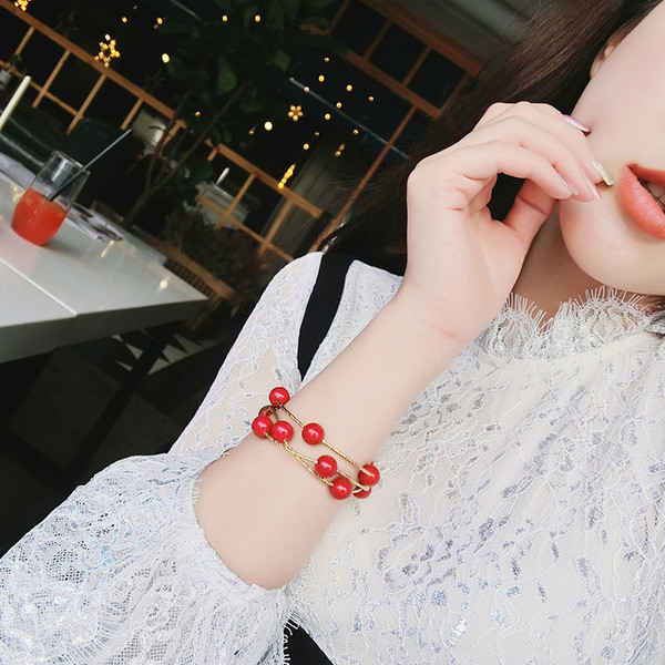 Modern női karkötő piros gyöngyökkel