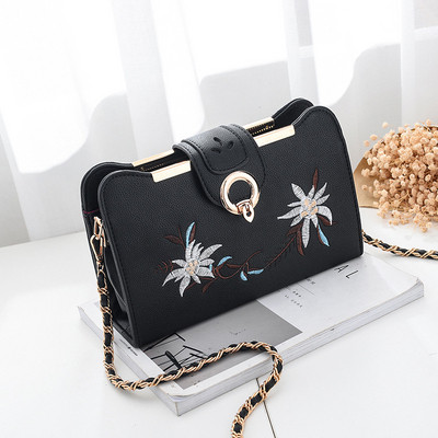 Hímzéssel és fém fogantyúval ellátott női táska