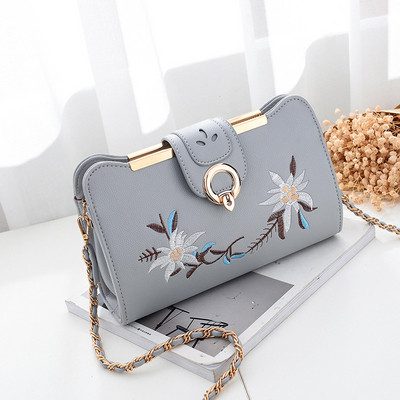 Hímzéssel és fém fogantyúval ellátott női táska