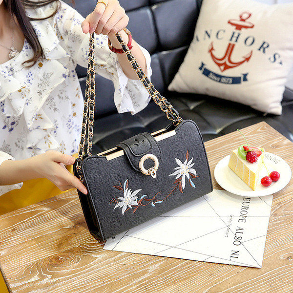 Hímzéssel és fém fogantyúval ellátott női táska